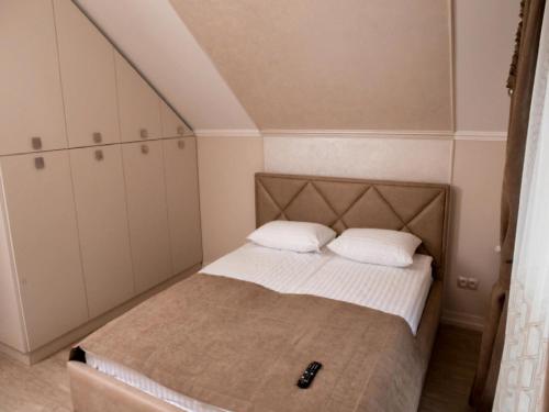 a small bedroom with a bed with two pillows at Apartment Sweethome 4 FREE PARKING in Uzhhorod