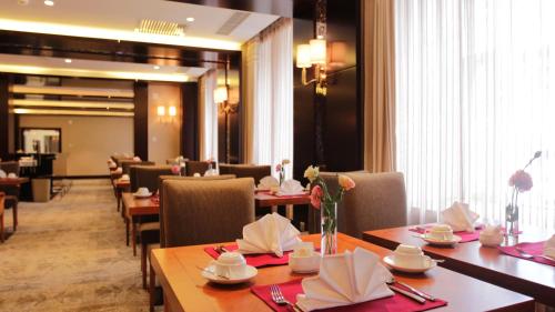 a dining room with wooden tables and chairs and a unintention at Best Western Premier Tuushin Hotel in Ulaanbaatar