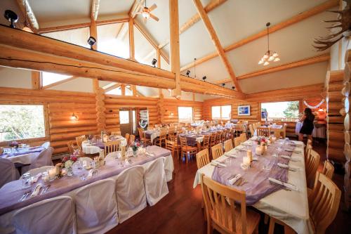 a dining room with tables and chairs and a woman at Majestic Valley Wilderness Lodge in Sutton