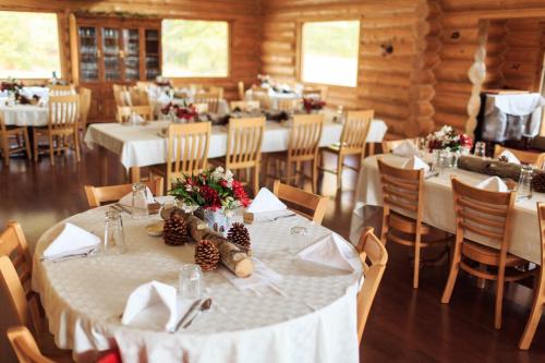 a dining room with tables and chairs with white table linen at Majestic Valley Wilderness Lodge in Sutton