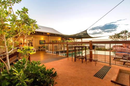 a patio area with tables, chairs and umbrellas at Cygnet Bay Pearl Farm in Dampier Peninsula