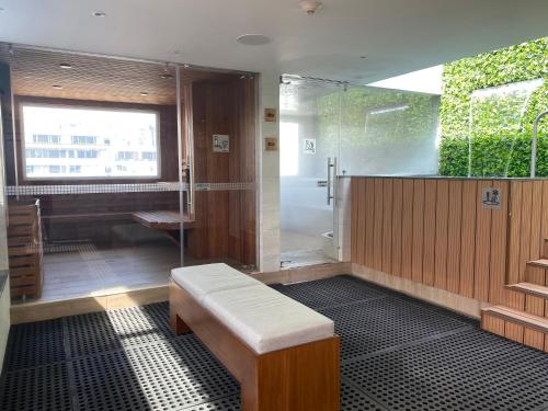 a bathroom with a shower and a bench in it at Mercure Alameda Quito in Quito
