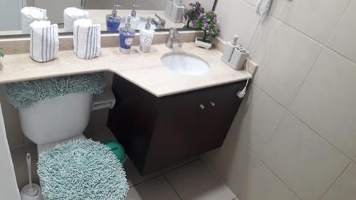 a bathroom with a sink and a toilet at Condominio Mar Egeo Iquique in Iquique