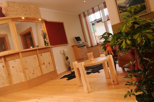 a living room with a table and a potted plant at Hotel Tauernstern in Winklern