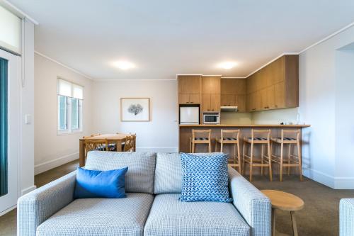 a living room with a couch and a kitchen at Portsea Village Resort in Portsea