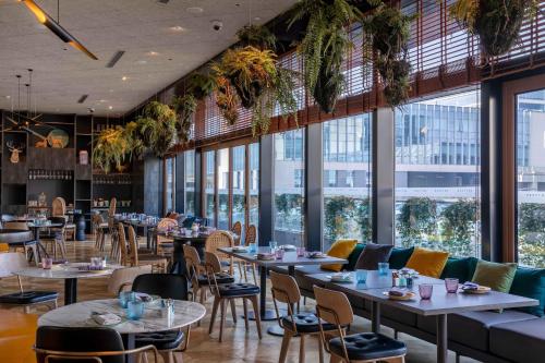 a restaurant with tables and chairs and windows at Artyzen Habitat Hongqiao Shanghai - Korean Street in Shanghai