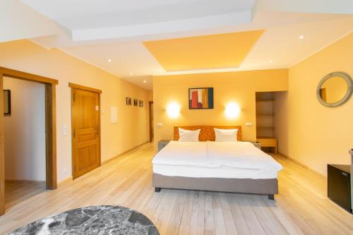 a bedroom with a large bed and yellow walls at Aux Tanneries de Wiltz in Wiltz