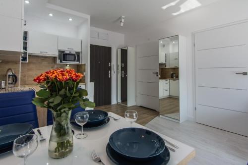 a dining table with a vase of flowers on it at Apartamenty Izerskie - ul. Sienkiewicza 9 in Świeradów-Zdrój