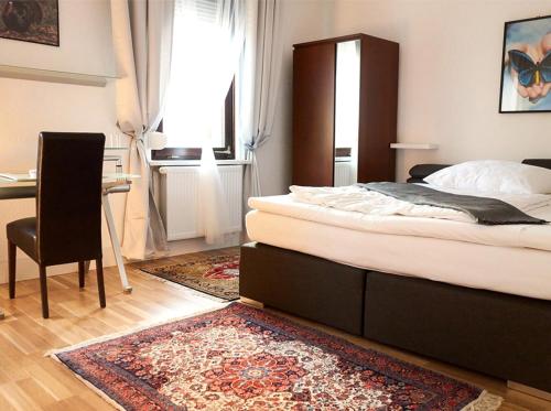 um quarto com uma cama, uma secretária e uma cadeira em Apartments Ho30 em Stuttgart