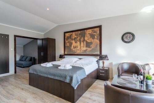 a bedroom with a bed with a painting on the wall at Apartamenty K2 Podmurna 36 in Toruń