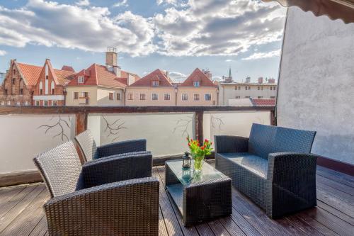 a patio with chairs and a table on a balcony at Apartamenty K2 Podmurna 36 in Toruń