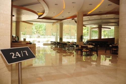 a restaurant with tables and chairs in a building at The Lalit Chandigarh in Chandīgarh