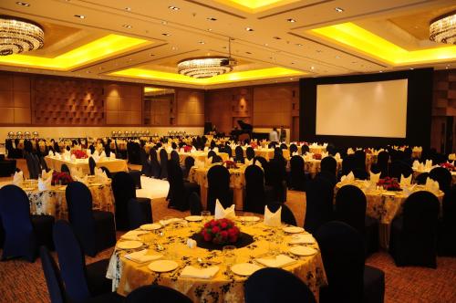 a banquet hall with tables and chairs and a screen at The Lalit Chandigarh in Chandīgarh