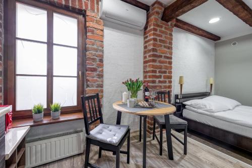 a room with a bed and a table and chairs at Apartamenty K2 Podmurna 36 in Toruń