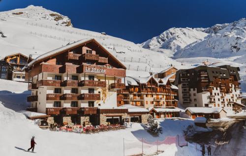 a ski lodge in the snow in front of a mountain at Hôtel Le Sherpa Val Thorens in Val Thorens