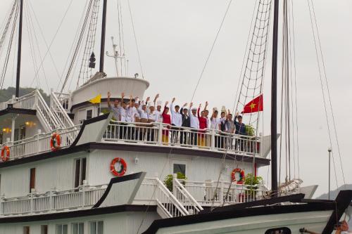 a group of people standing on the deck of a boat at Signature Halong Cruise in Ha Long