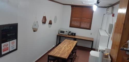 uma cozinha com uma mesa de madeira num quarto em Kimstay 9 em Seul