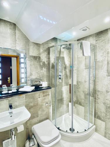 a bathroom with a shower and a toilet and a sink at Beresford Hotel in Dublin