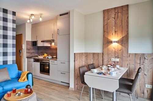 kuchnia i salon z niebieską kanapą w obiekcie Haus Pamir _ Fewo 25 w mieście Cuxhaven