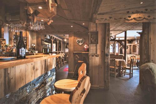 a restaurant with a bar with two tables and chairs at Hôtel Le Sherpa Val Thorens in Val Thorens