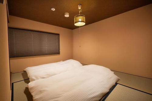 Postel nebo postele na pokoji v ubytování Kanade Inari-Sandomae