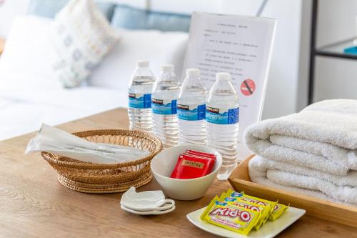 a table with bottles of water and a basket of towels at Art Station x Residence in Tainan