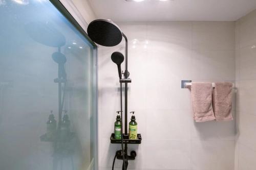 a bathroom with a shower with two bottles on a shelf at Jingyi Apartment in Shanghai
