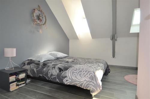 a bedroom with a bed with a black and white blanket at Appartement moderne avec terrasse à 500m de la mer in Courseulles-sur-Mer