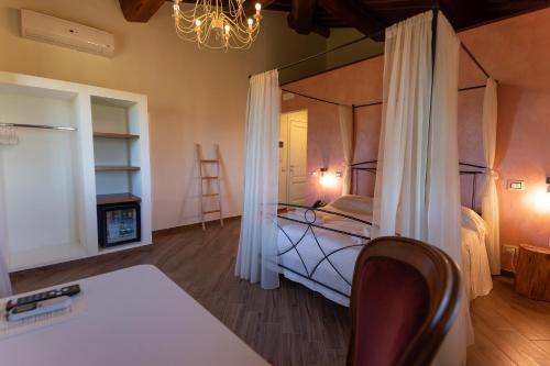 a bedroom with a canopy bed and a chair at Fattoria L'Olmetto in Pisa