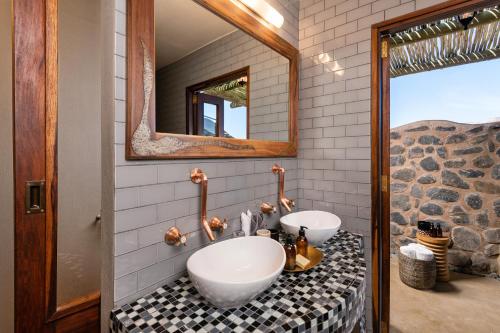ein Badezimmer mit 2 Waschbecken und einem Spiegel in der Unterkunft Hoodia Desert Lodge in Sesriem