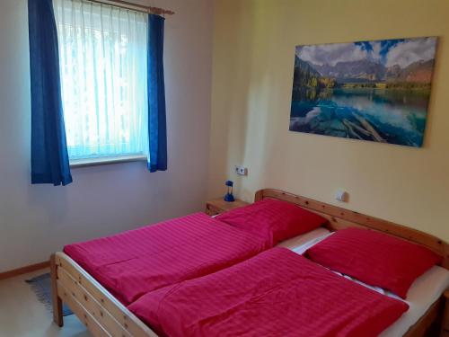 GrossbreitenbachにあるFerienhaus Bad Hundertpfund Typ Cのベッドルーム1室(赤いシーツを使用したベッド2台付)