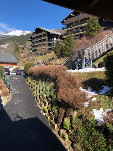a walkway with plants on the side of a building at La chaumière des neiges in Châtel