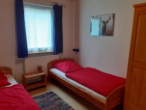 a bedroom with two beds and a window at Ferienhaus Bad Hundertpfund in Grossbreitenbach