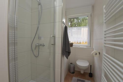 y baño blanco con ducha y aseo. en Ferienhaus am Fusse des Rennsteig/ Haus Anna en Suhl