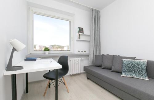 a living room with a couch and a desk at Rooms4Less in Gdańsk