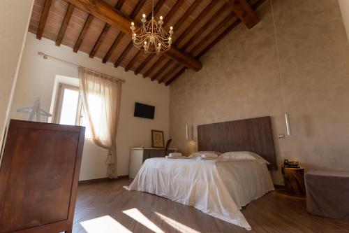 a bedroom with a large bed and a chandelier at Fattoria L'Olmetto in Pisa