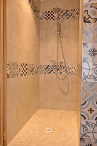 a shower with a shower head in a bathroom at Le Chant du coucou in Huy