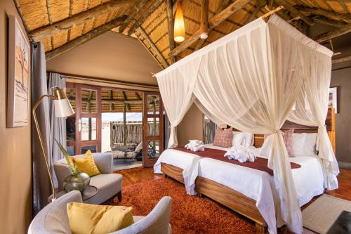 sypialnia z łóżkiem z baldachimem w obiekcie Hoodia Desert Lodge w mieście Sesriem