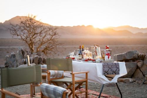 a dinner table in the middle of the desert at Hoodia Desert Lodge in Sesriem