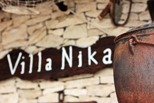 a sign that says villa nikka on a stone wall at Charming Villa Nika with the pool in Supetar