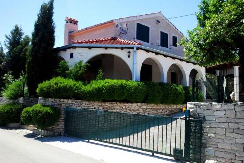 una casa con una valla delante de ella en Charming Villa Nika with the pool, en Supetar