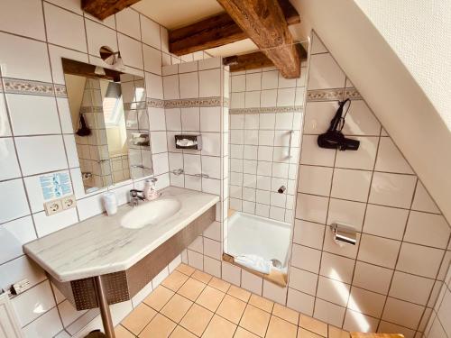 a bathroom with a sink and a bath tub at Stadthotel Waldhorn in Kirchheim unter Teck
