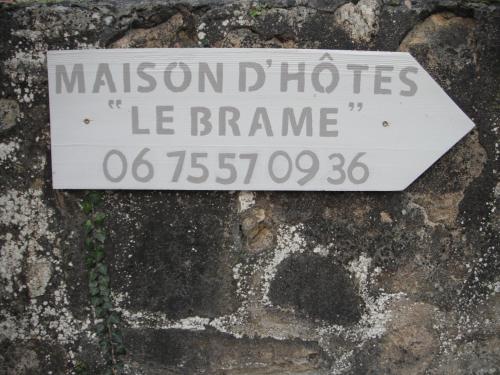 a sign on the side of a stone wall at Le Brame - Chambres d'Hôtes in Avilly-Saint-Léonard