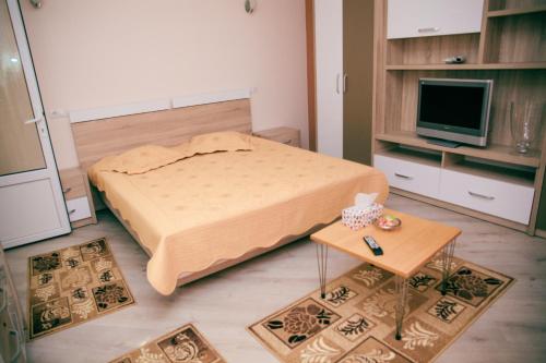 - une petite chambre avec un lit et une table dans l'établissement Apartament Cora Centru Pitesti, à Piteşti