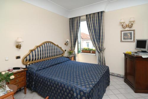 a hotel room with a bed and a television at Amalfi Old Square room & apartments , 73 steps from the street in Amalfi