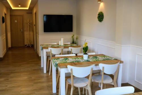 a dining room with tables and chairs and a flat screen tv at Gościniec przy Spacerowej in Długołęka