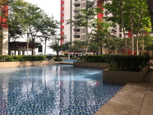 een zwembad in een gebouw met bomen en gebouwen bij Main Place Resort Family Suite in Subang Jaya