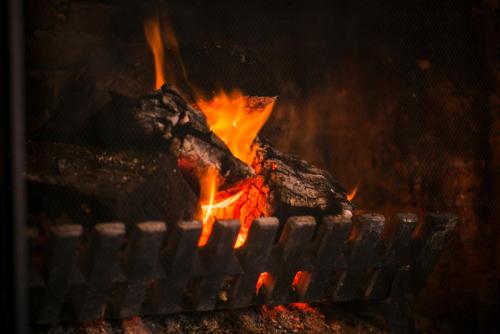 a fire in a grill with meat in it at Coul House Hotel in Contin
