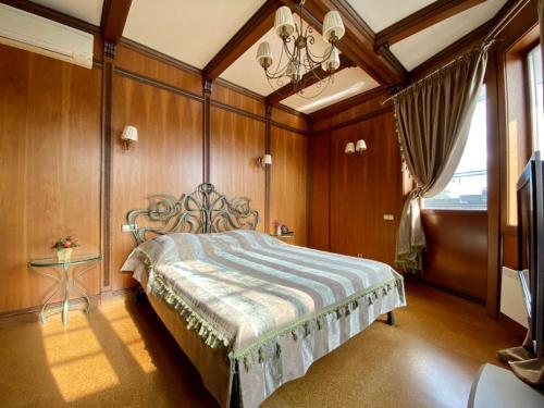 1 dormitorio con 1 cama en una habitación con paredes de madera en On The River, en Vishenki