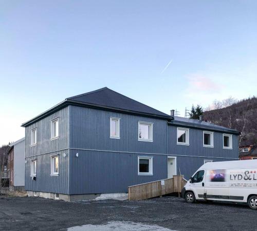 um edifício com uma carrinha estacionada em frente em Mosjøen Overnatting, Vollanvegen 13 em Mosjøen